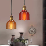 Orange and red gridded pendants above a table set with vases