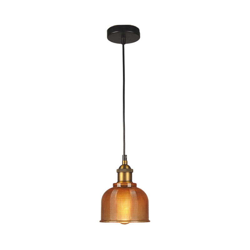 Orange gridded glass bell shade lit warm on a plain background