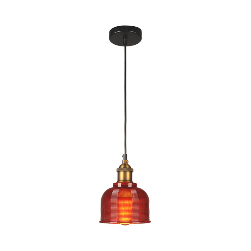 Red gridded glass bell shade and brass socket on a plain background