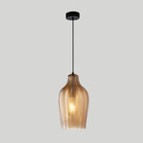 Cognac ribbed pendant with a tall bottle shade, lit on grey