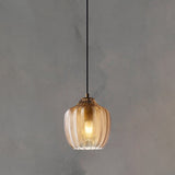Cognac ribbed pendant lit warm against a plain grey backdrop