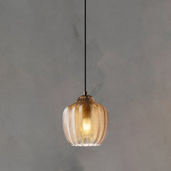 Cognac ribbed pendant lit warm against a plain grey backdrop
