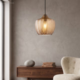 Cognac ribbed pendant lit above a sideboard and a round stone