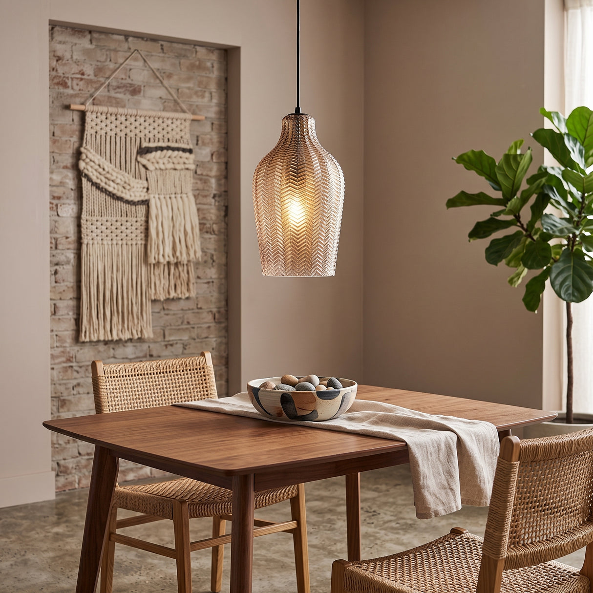 Cognac ribbed glass pendant lit above a table by a woven hanging