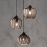 Three ribbed pendants in cognac and smoke on a marble wall