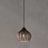 Smoke ribbed pendant lit warm against a plain grey backdrop