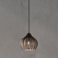 Smoke ribbed pendant lit warm against a plain grey backdrop