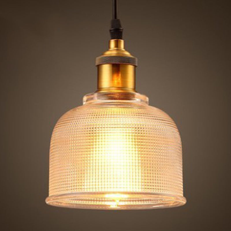 Amber bell pendant lit warm with a brass socket and black cord