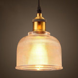 Amber bell pendant lit warm with a brass socket and black cord