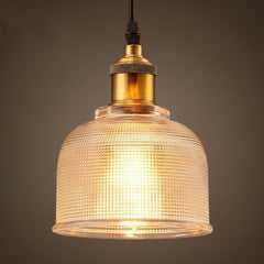 Amber bell pendant lit warm with a brass socket and black cord