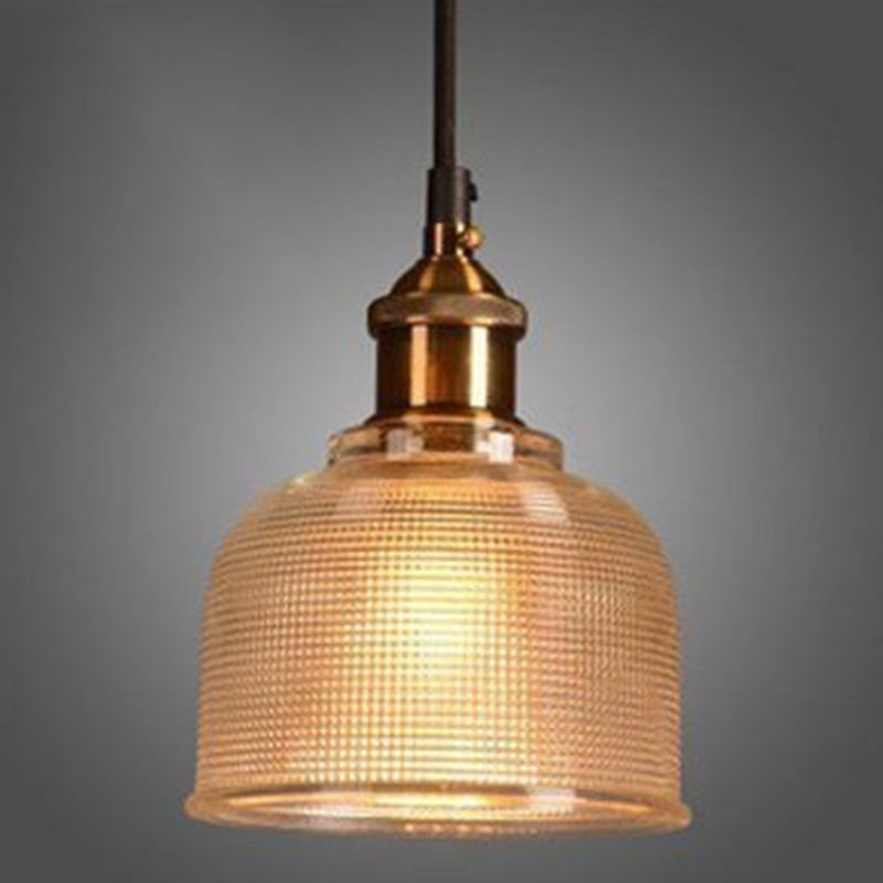 Amber ribbed glass pendant lit on a gray studio background