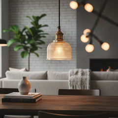 Amber ribbed glass pendant lit on a gray studio background