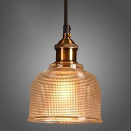 Amber ribbed glass pendant lit on a gray studio background