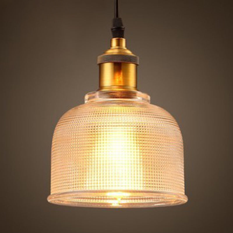 Clear bell pendant lit warm showing the ribbed glass texture