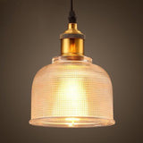 Clear bell pendant lit warm showing the ribbed glass texture