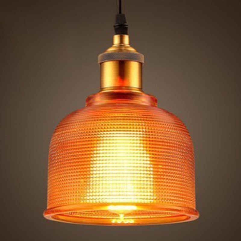 Orange ribbed glass bell pendant lit against a dark background