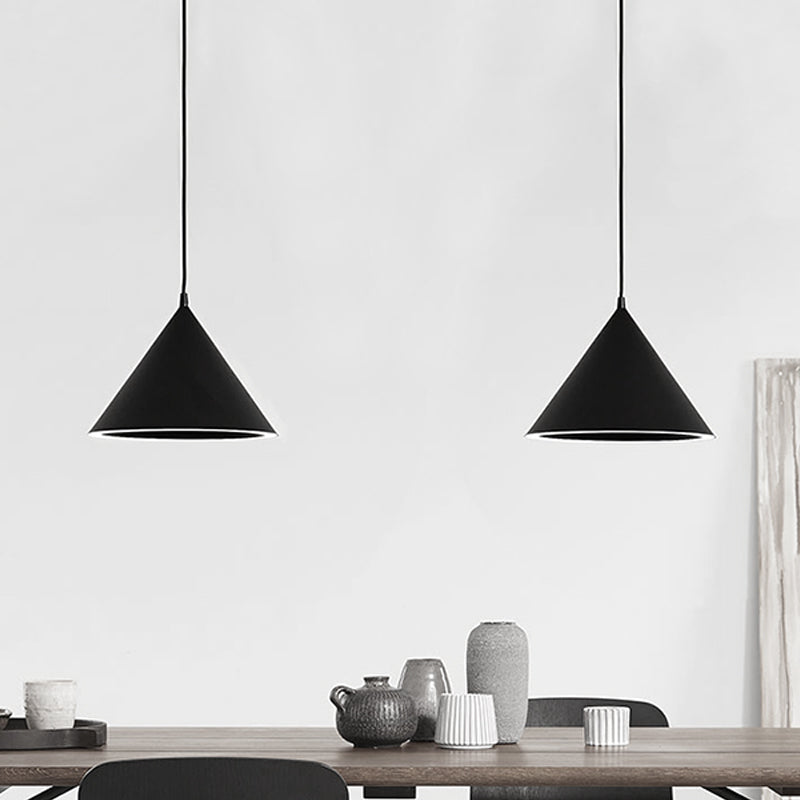 Two black cone pendants lit above a table set with grey crockery