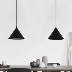 Two black cone pendants lit above a table set with grey crockery