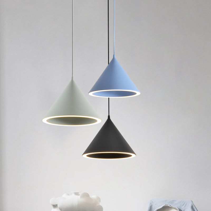Green, blue and black cone pendants lit above a dining table