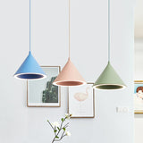 Blue, pink and green cone pendants hanging beside a framed print