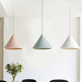 Pink, green and white cone pendants against a white gallery wall