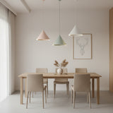 Pink, white and green cone pendants shown lit on a plain wall