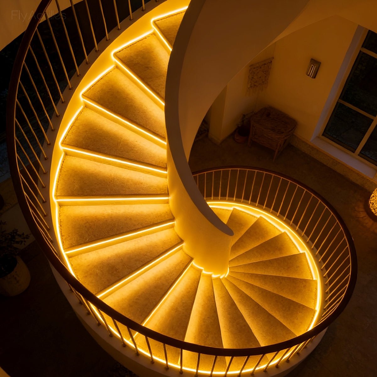 Curved staircase lit from beneath each tread by a continuous warm strip