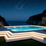 Poolside terrace at night with strip lighting along the steps and edging