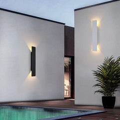 Slim black outdoor LED wall light glowing on a rendered garden wall