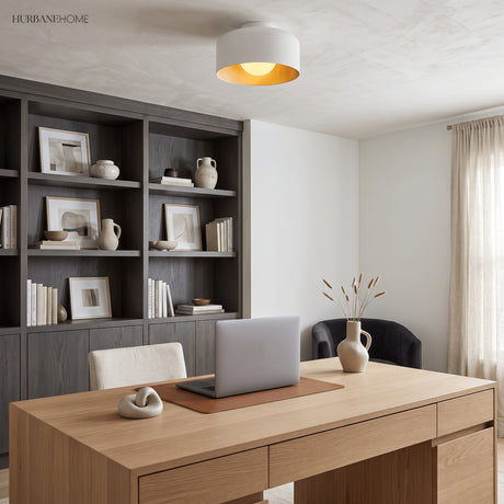 Drum ceiling light with lit wood grain interior above a pale timber desk
