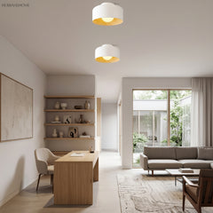 Two white drum ceiling lights above an oak dining table and open shelving