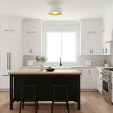 White drum flush mount lit above a kitchen island in a white shaker kitchen