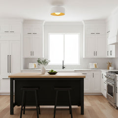 White drum flush mount lit above a kitchen island in a white shaker kitchen