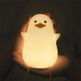 Duck silicone night light held in two hands showing its soft warm glow