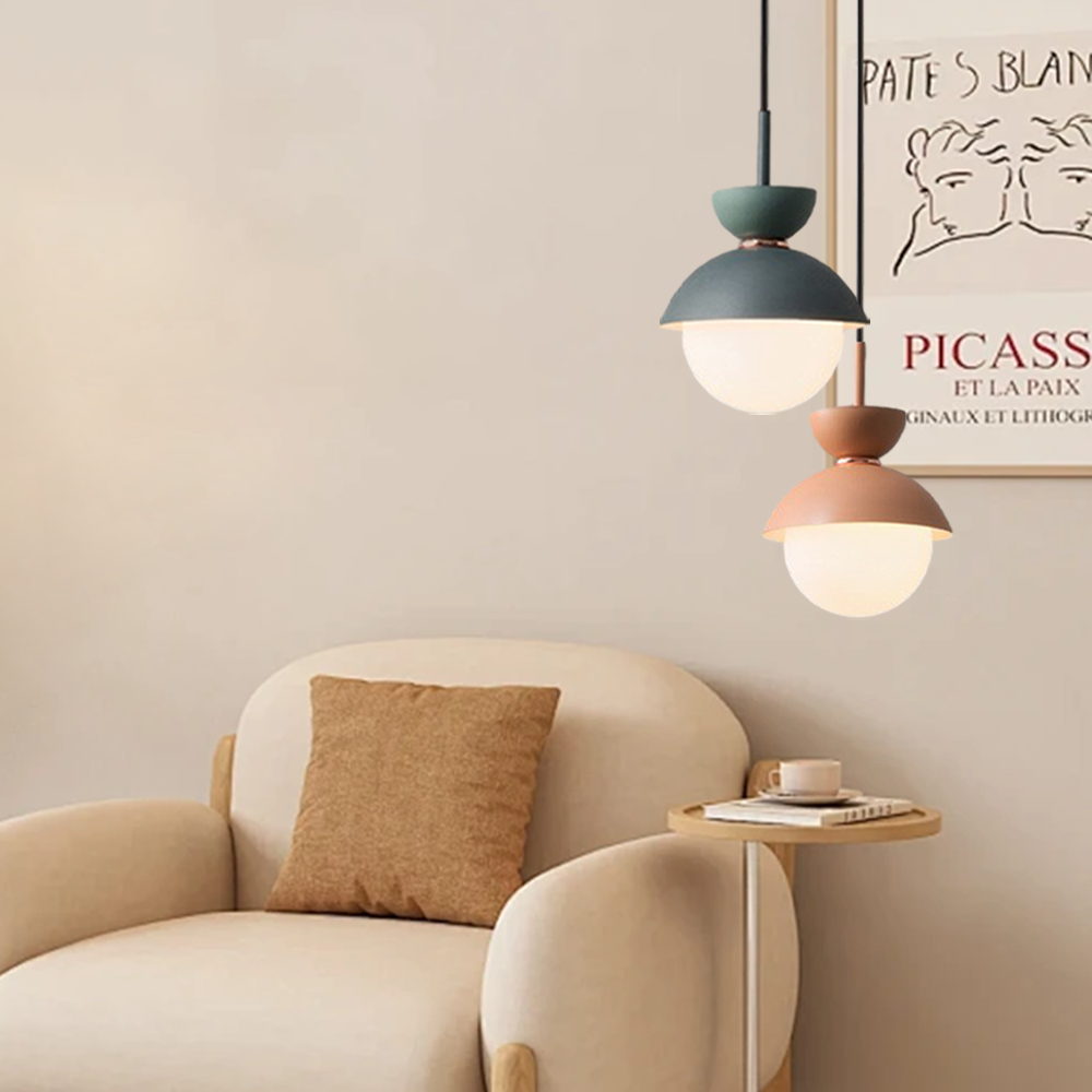 Pink macaron pendant light viewed from the side with copper collar detail