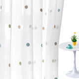 Embroidered white sheer curtains adding soft privacy to dining area