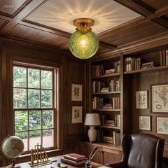 Green engraved glass globe ceiling light in a panelled wood study