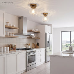 Two clear glass globe ceiling lights above a white kitchen and island