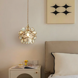 Close detail of engraved glass petals framed in brass on the pendant light
