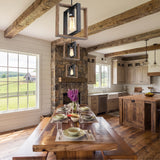 Three caged iron and wood pendants above a long timber table under beams