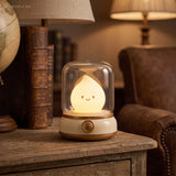 Warm flame night light on a hall table beside a leather armchair and stacked books