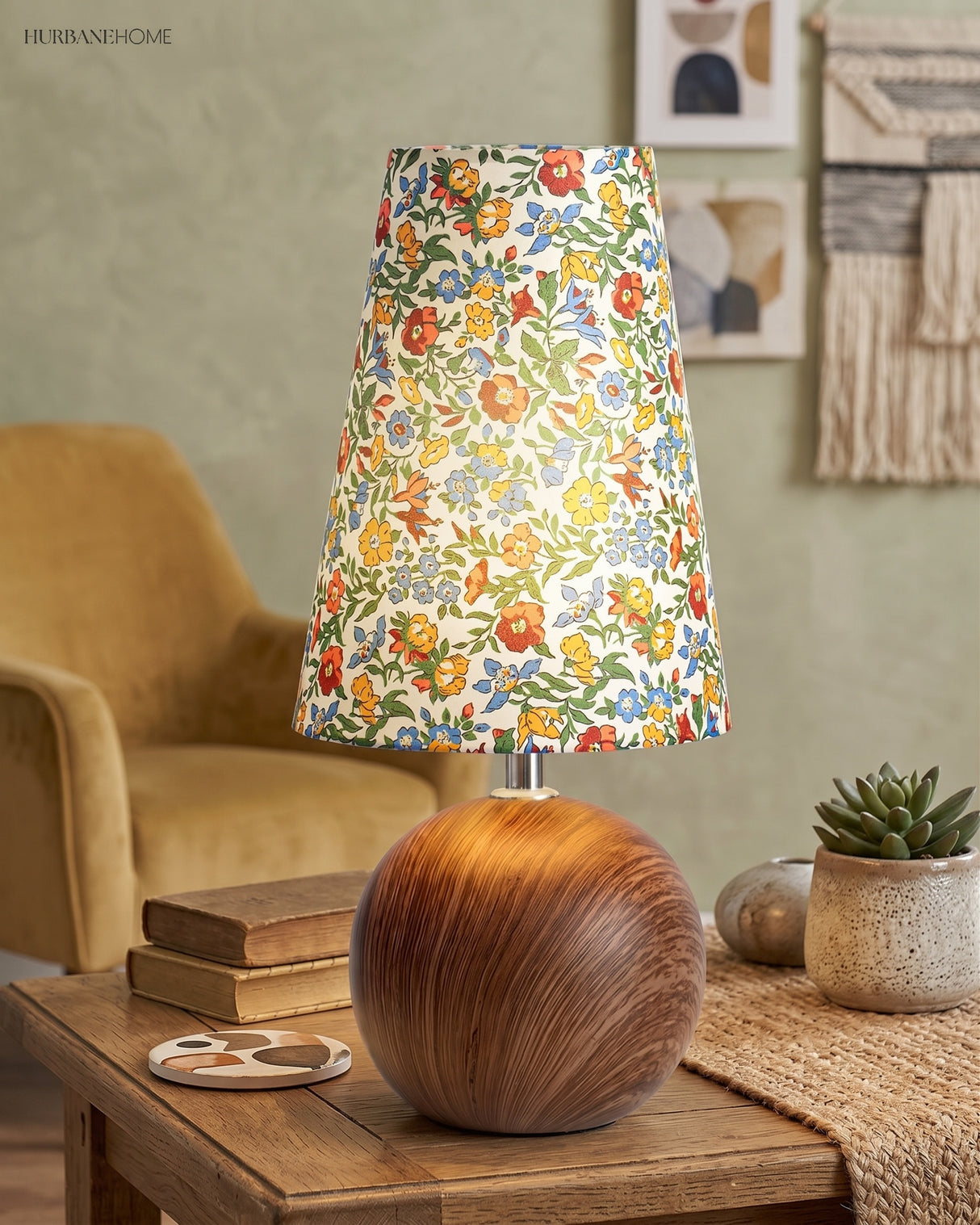 Small floral table lamp lit on a side table in a sage green sitting room