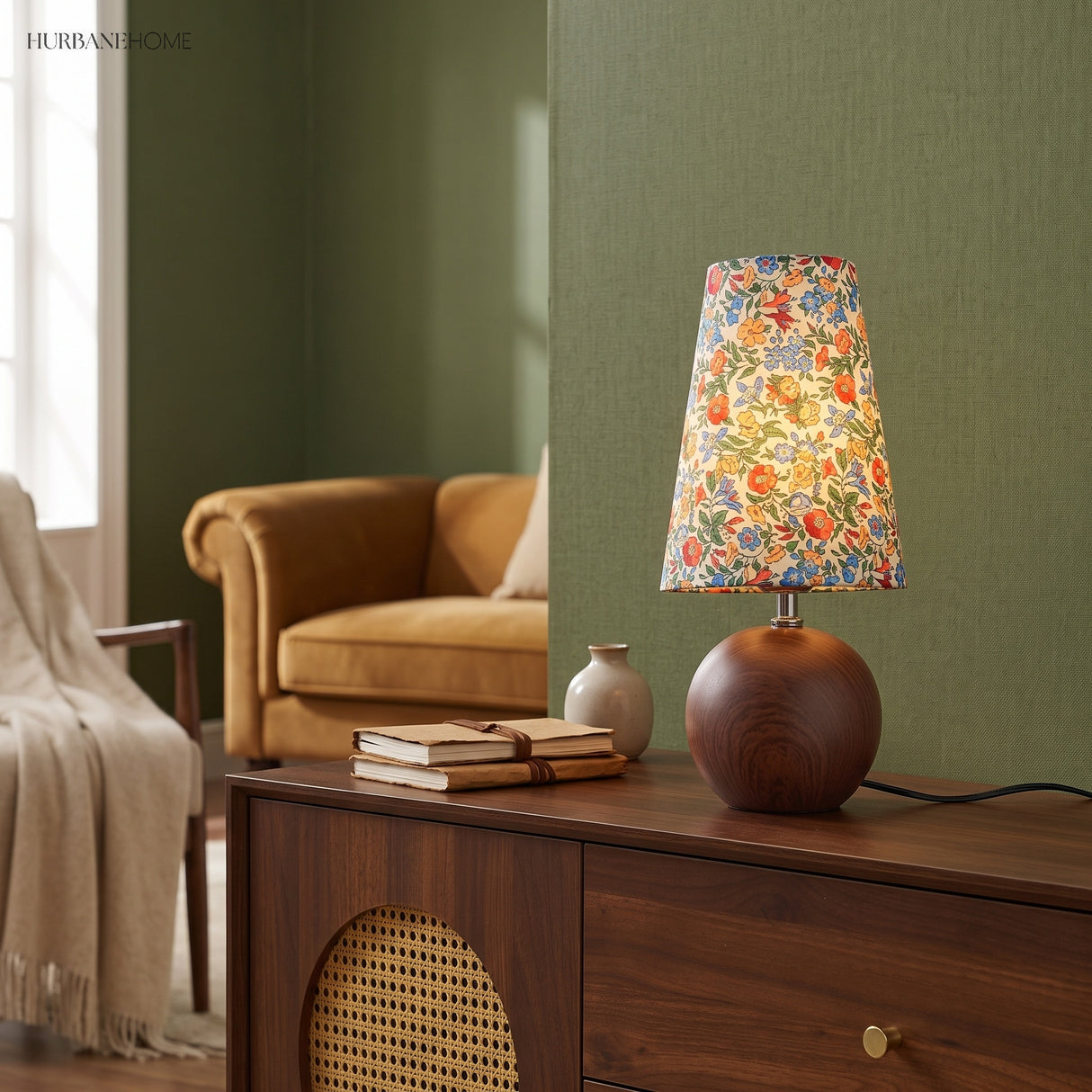Vintage floral table lamp on a walnut sideboard against a deep green wall