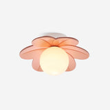 Studio view of the pink petal ceiling light lit, showing the frosted glass globe