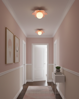 Flower ceiling lights above a soft pink hallway with framed art and a runner