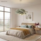 Sage green flower pendant light above a bed in a calm bedroom