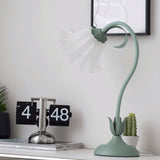 Flower table lamp on a white console beside a chrome flip clock and cactus