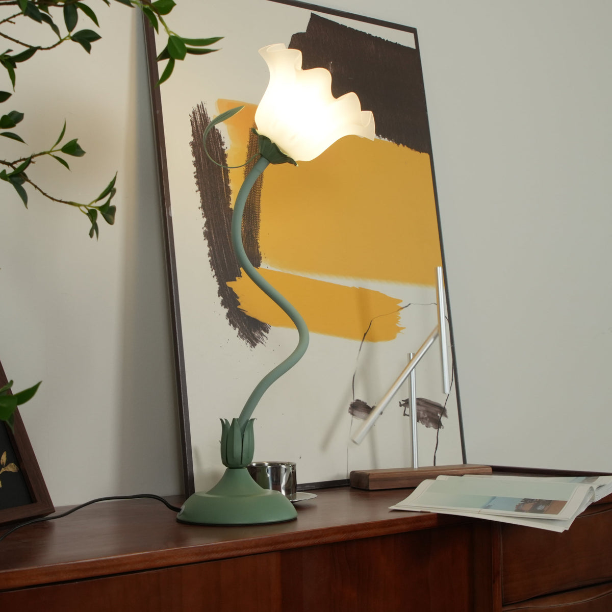 Lit flower table lamp showing the curved green stem and open white petal shade