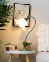 Flower table lamp lit on a white round side table beside a retro radio