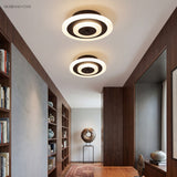 Two round coffee ceiling lights along a corridor with bookshelves